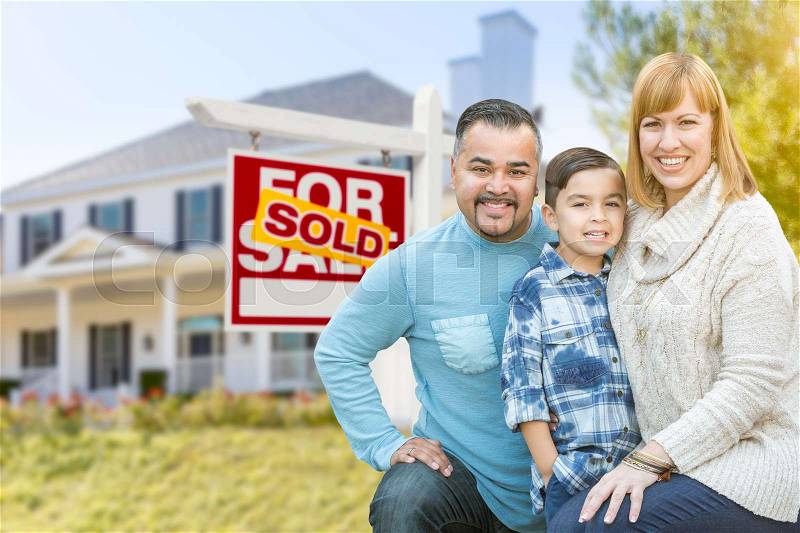 Happy Mixed Race Hispanic and Caucasian Family Portrait In Front of House and Sold For Sale Real Estate Sign, stock photo