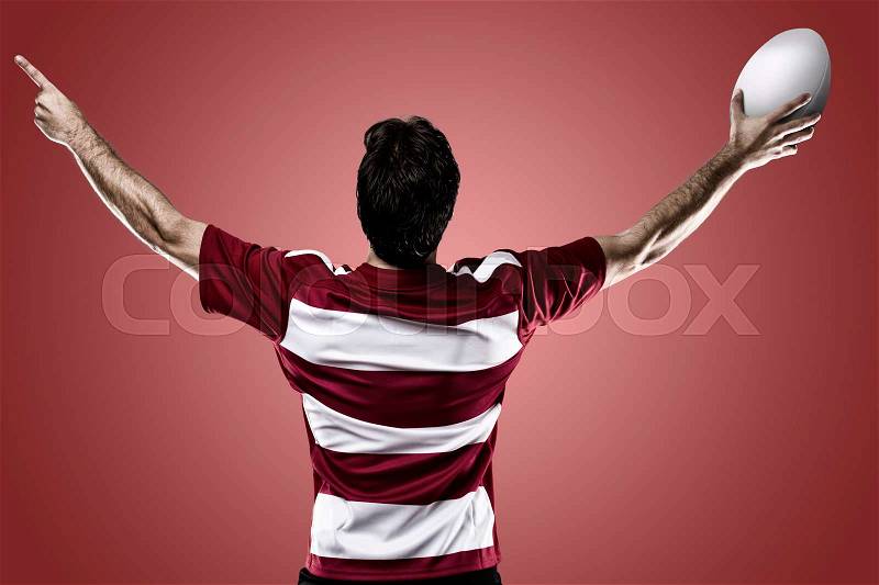 Rugby player in a red uniform celebrating on a red background, stock photo