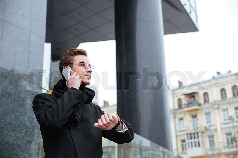 Business man with phone on the street. side view. from below, stock photo