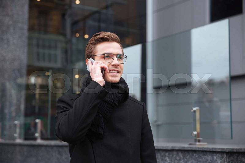 Business man talking at phone near the office. man in glasses, stock photo