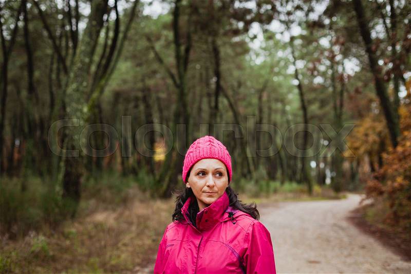 Matured woman with wool pink hat in the forest, stock photo