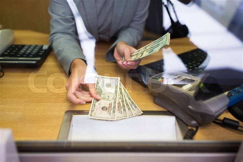 People, withdrawal, saving and finance concept - clerk giving cash money to customer at bank office or currency exchanger, stock photo