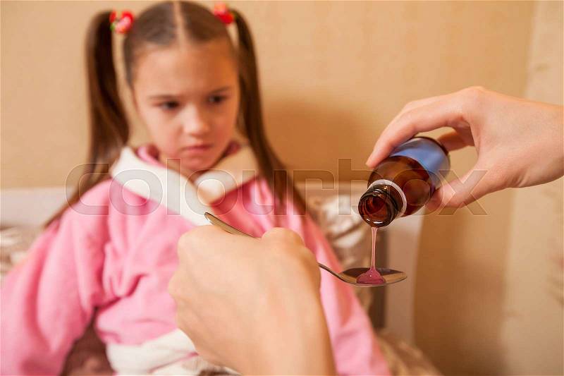 Little girl is going to take medicine. Tablets and drugs concept, stock photo