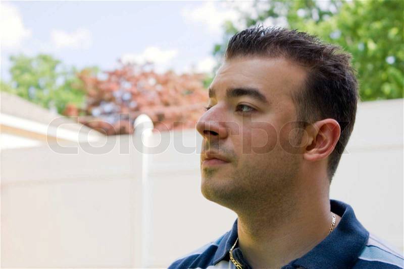 A young Italian man with spiked hair outside in the backyard, stock photo