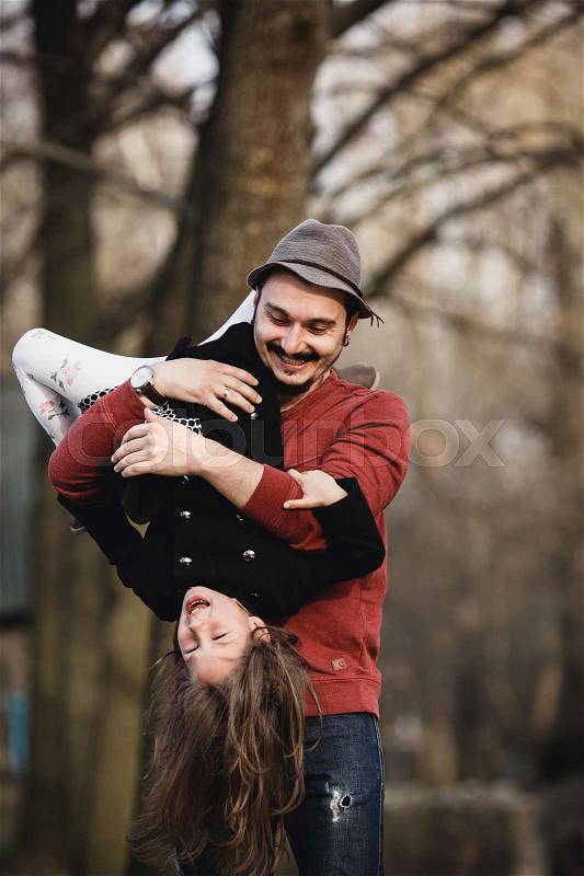 Dad holding his daughter upside down on his hands, stock photo