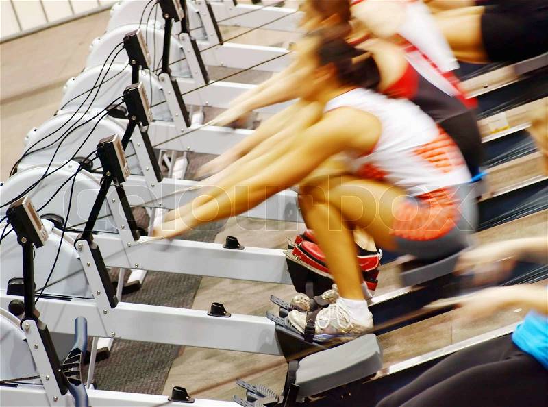 Women exercising in the gym on rowing machines, stock photo