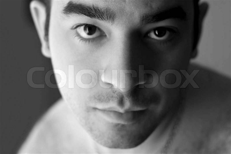A portrait of a young man with a serious or concerned look on his face - black and white, stock photo