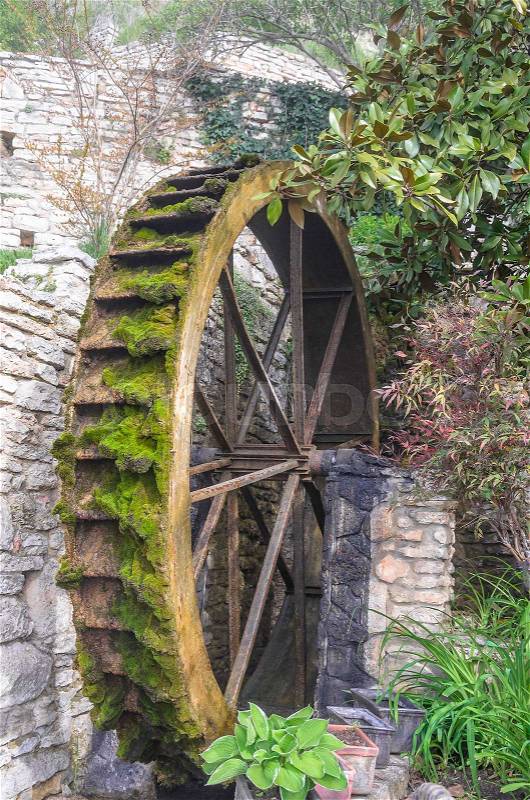 Wheel of an old water mill overgrown with with moss, stock photo