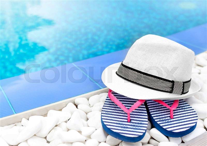 Flip-flops and hat at the pool on the white gravel, stock photo