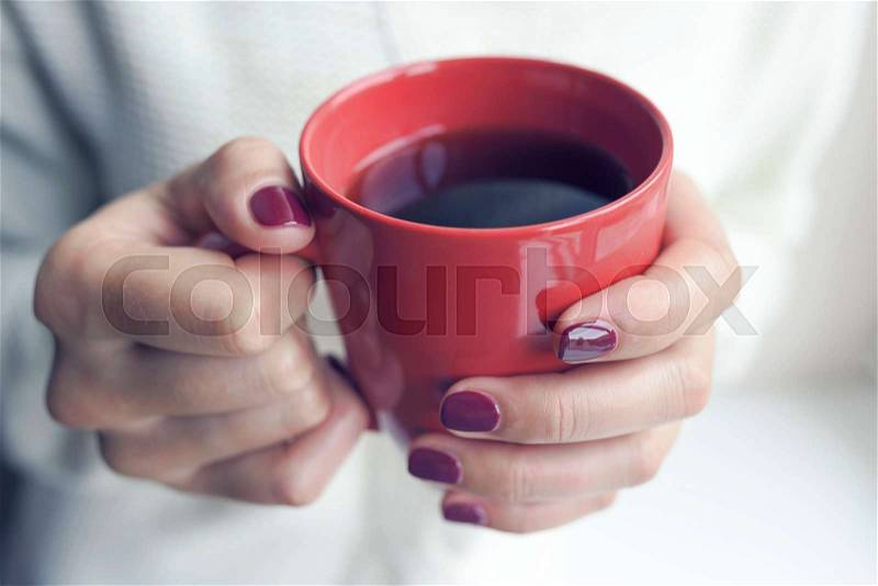 Cup of tea or coffee in female hands close up. Toned photo, stock photo