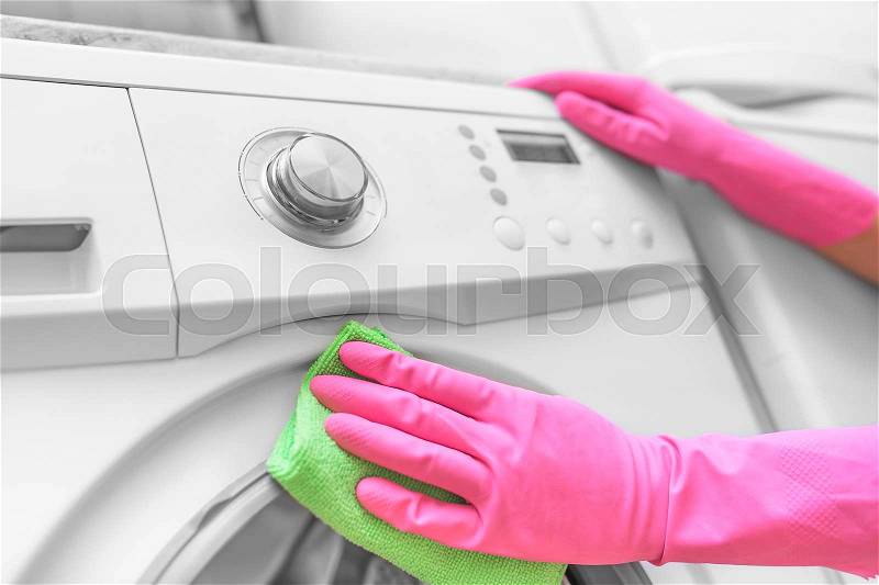 Female hands in gloves washing washing machine. Close-up, stock photo