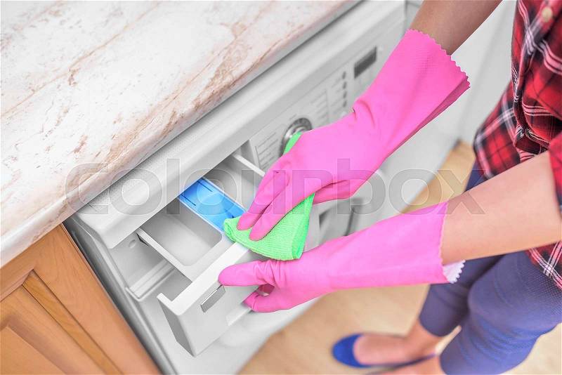 Female hands in gloves washing washing machine. Close-up, stock photo