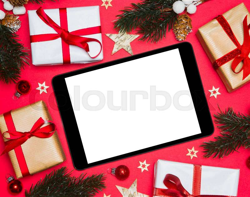 Tablet and tablet in Christmas red background with tree, gift and decoration, stock photo