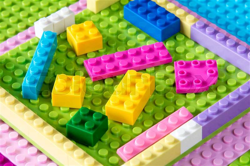 Baseplate with colorful plastic building blocks. Toys background, stock photo