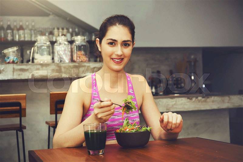 Attractive Caucasian fitness woman is eating salad with healthy glass of juice - Fitness and Diet concept, stock photo