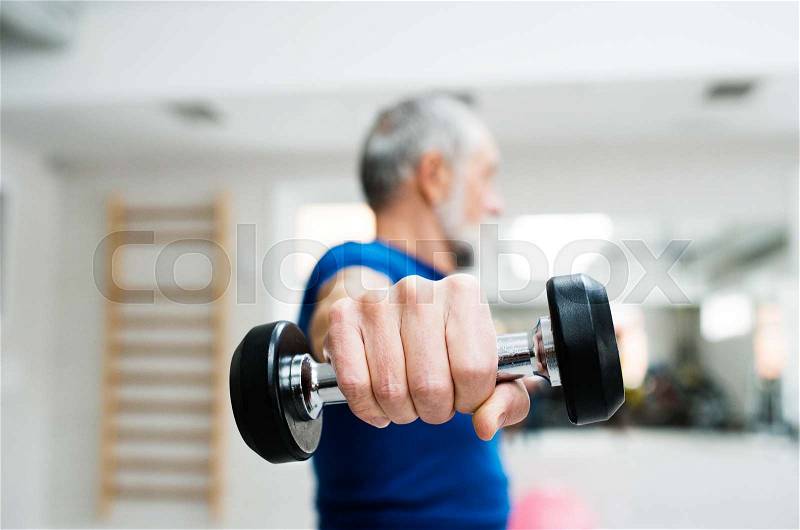 Senior man in sports clothing in gym working out with weights. Close up of hands, stock photo