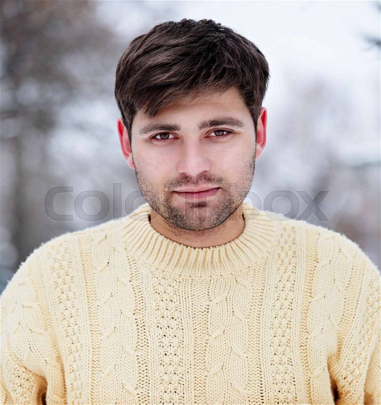 Portrait of a handsome young man in a knitted sweater, stock photo