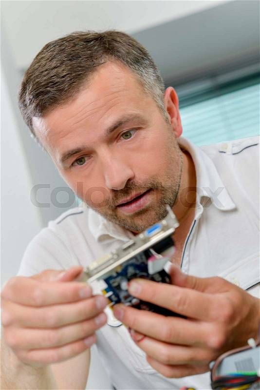 Man repairing a video card, stock photo