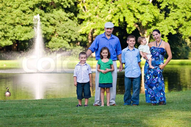 An attractive young family together at the park together on a nice spring or summer day, stock photo