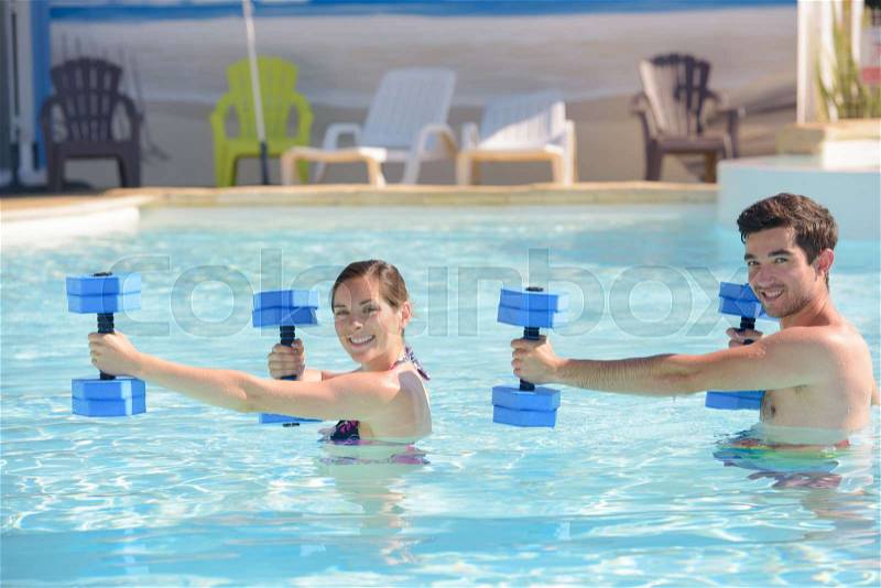 Couple doing sports under water in swimming pool, stock photo