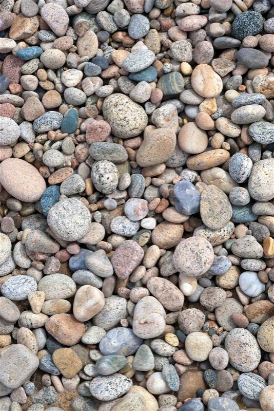 A close up view of smooth polished stones washed ashore on the beach, stock photo