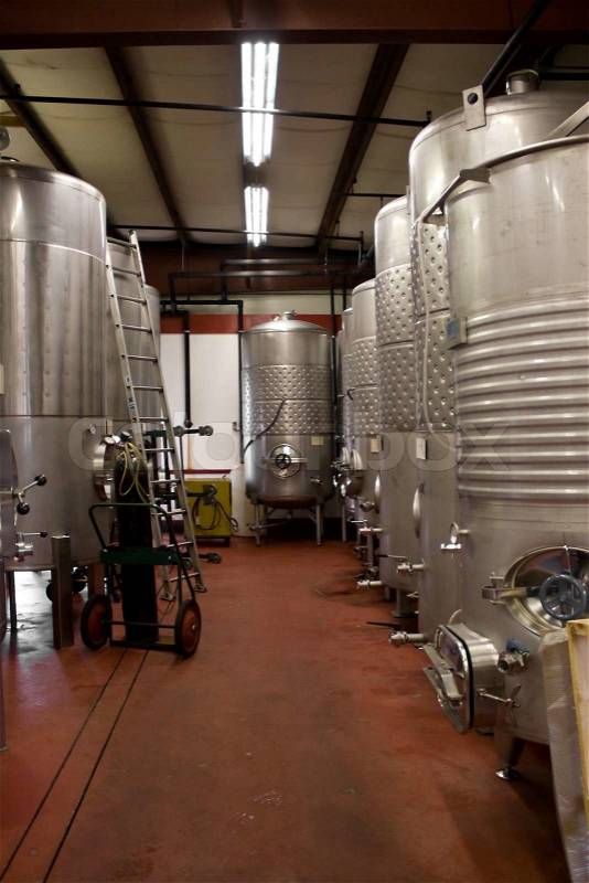 Modern aluminum storage tanks where grape juice is aged into wine located in a vineyard cellar, stock photo