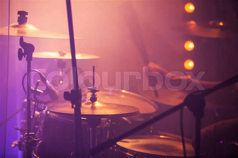 Live rock music background, drummer plays with drumsticks on rock drum set. Closeup photo, soft selective focus, stock photo