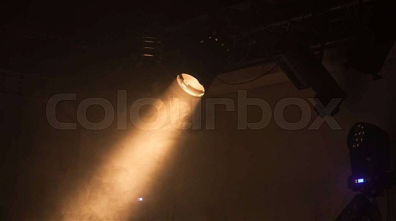 Ray of scenic spot light over dark smoky background, stage illumination equipment, stock photo