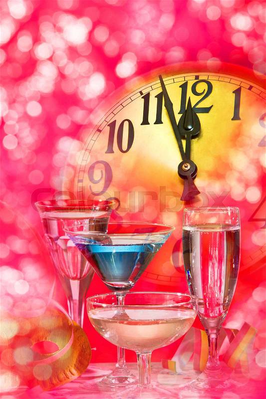 New year clock and wine glasses on the red background, stock photo