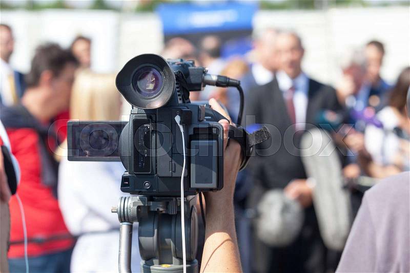 Filming news conference with a television camera, stock photo