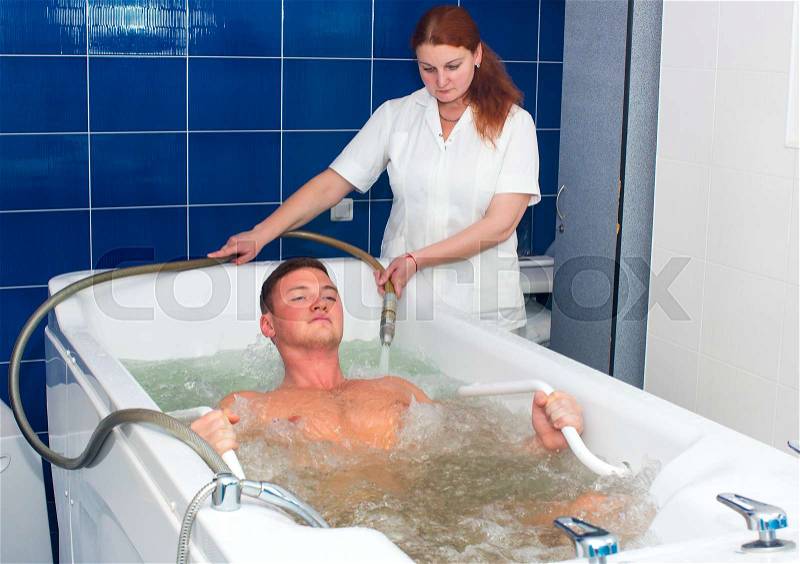 The young man is the procedure in the whirlpool hydrobath, stock photo