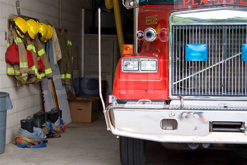 A fire truck is parked in the bay with all of the fire fighting equipment and gear ready to go, stock photo