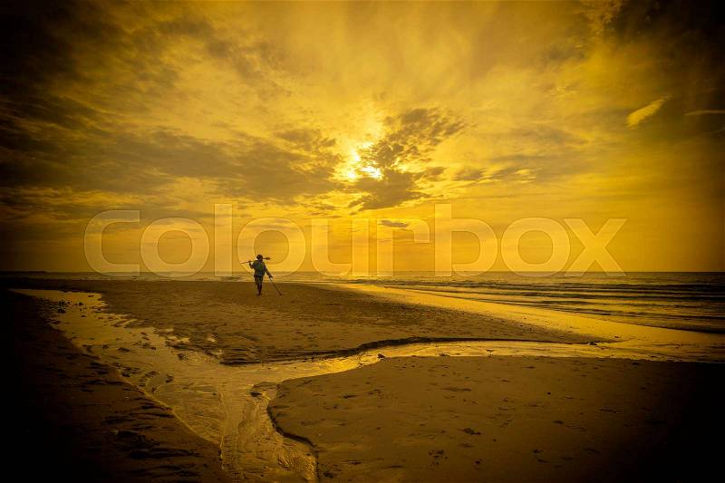 Abstract scene of man find out gold on the beach on yellow filter - can use to display or montage on product, stock photo