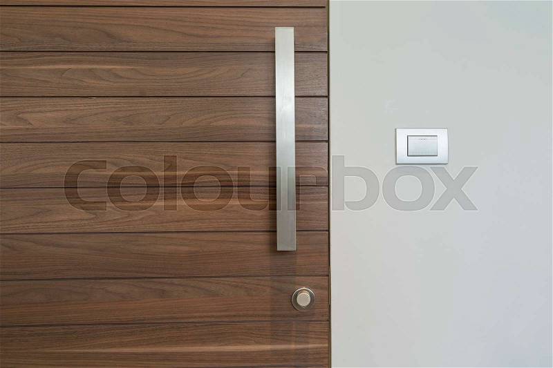 Modern wood door and silver handle and light switch on wall - can use to display or montage on product, stock photo
