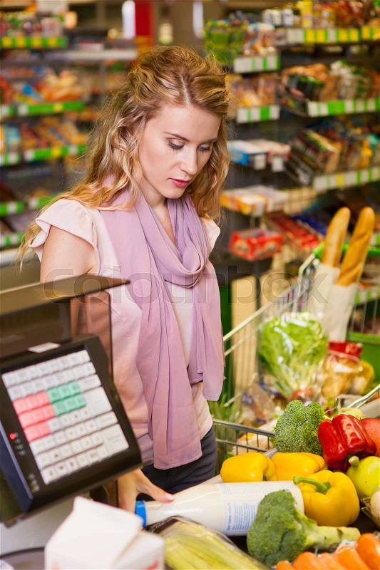 Young woman buying food at the grocery store, stock photo