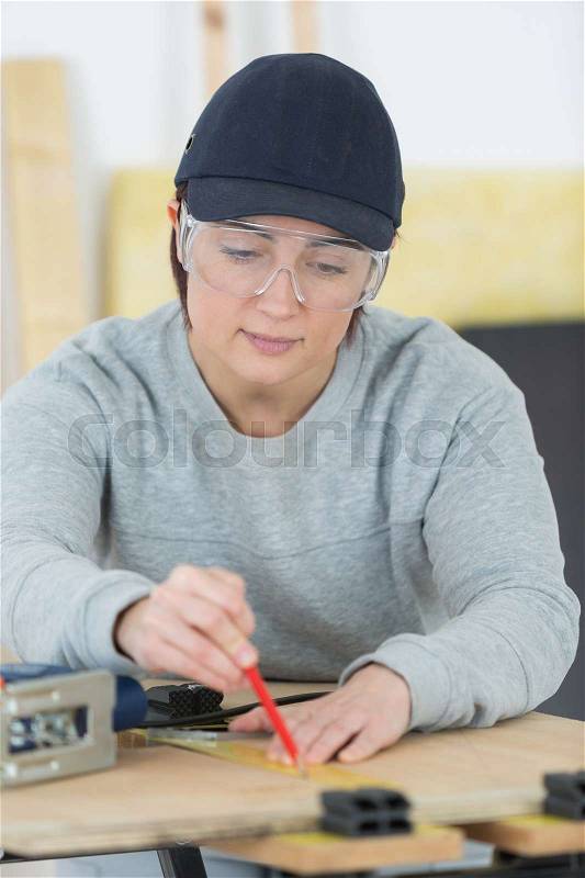 Portrait of happy female woodworker drafting new project at workshop, stock photo