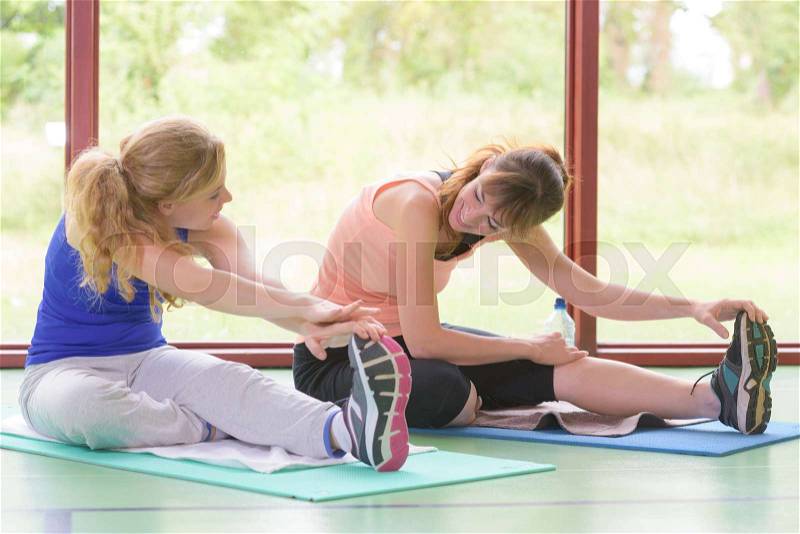 Ladies exercising, reaching for their toes, stock photo