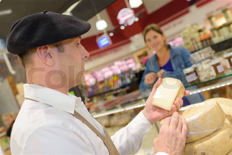 Woman buying cheese, stock photo
