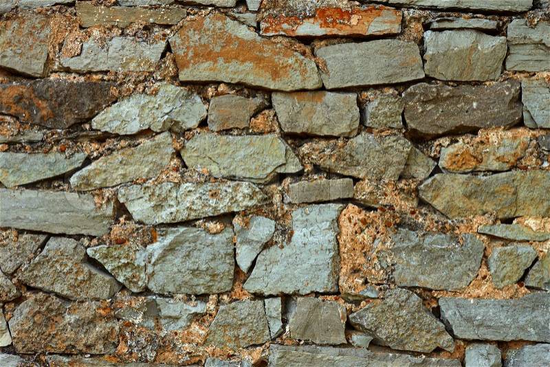 Detail of multicolor stone wall with coarse formless colored stones, stock photo