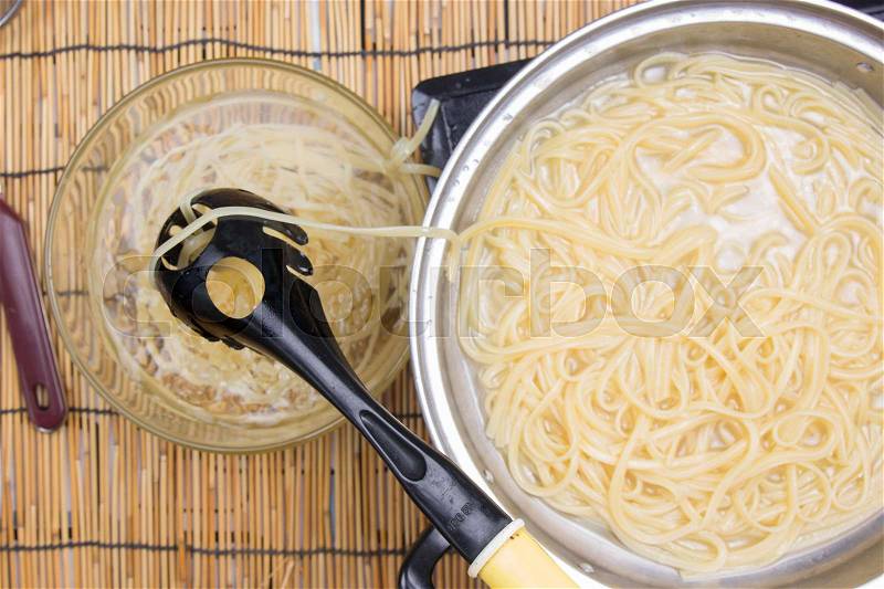 Spaghetti lifted on of cold water / cooking spicy spaghetti concept, stock photo