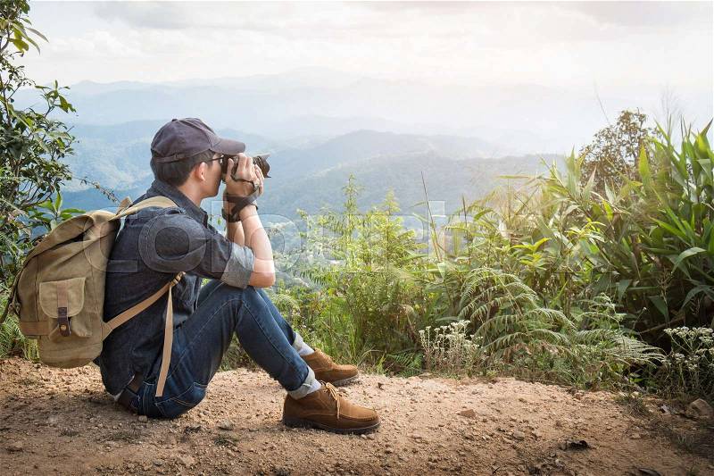 Young professional travrler man with camera shooting outdoor, fantastic mountain landscape, stock photo