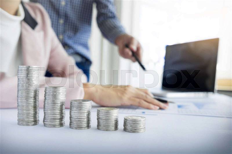 Person pointing writing goals on a paper,writing business plan at workplace,man holding pens ,papers,notes in documents,Saving money concept,graph, stacks of coins ,chart and pen, stock photo