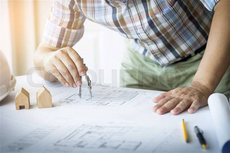 Close-up Of Person\'s Hand Drawing Plan On Blue Print with architect equipment, stock photo