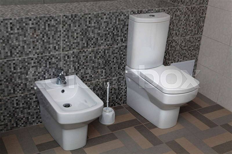 White toilet and bidet in a modern bathroom, stock photo