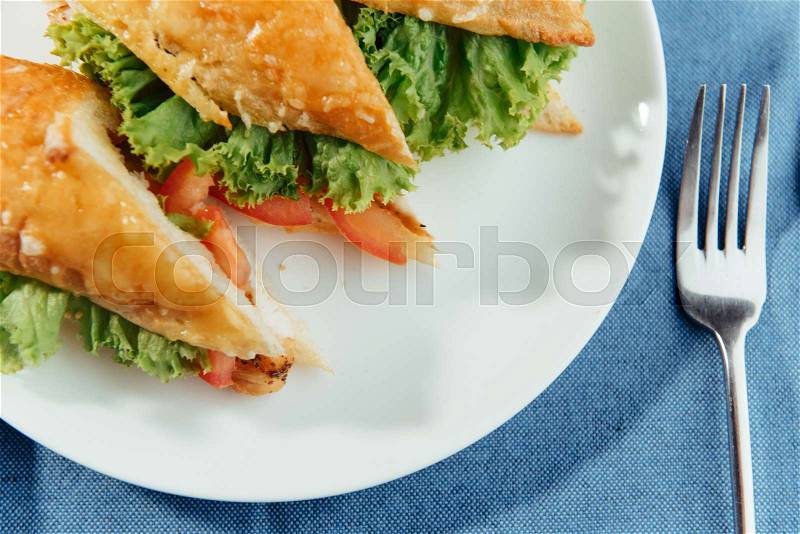 Healthy sandwich cut into pieces to show tasty ingredients salami, tomatoes, lettuce, stock photo