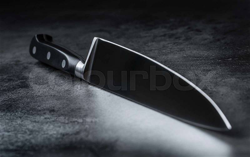 Knife. Kitchen knife lying on an modern concrete cutting board, stock photo