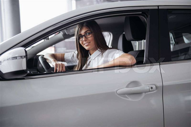 Pretty young woman driving her new car. Driving, stock photo