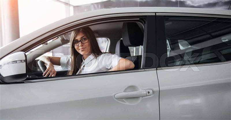 Pretty young woman driving her new car. Driving, stock photo