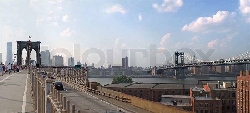 A panoramic image of the New York City skyline including the Brooklyn bridge the Manhattan bridge with the Empire State building in the far distance, stock photo