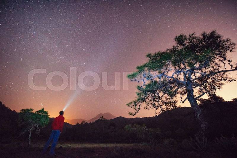 A person who feels on top of the world looking at the starry sky, stock photo